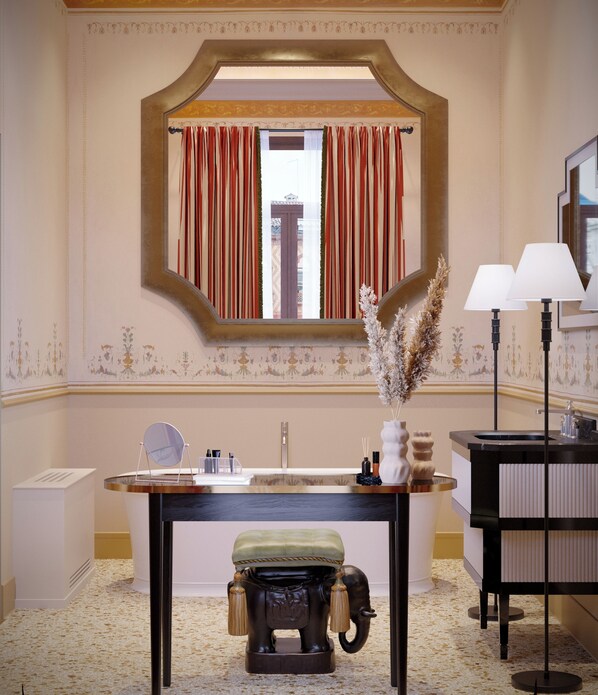 A hotel bathroom with a large mirror, a sink with a vanity, a toilet, and a window with curtains.