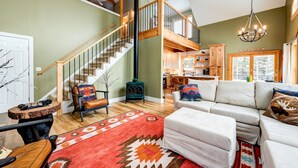 A spacious living room with a staircase, a fireplace, and a cozy seating area. - 5BR Retreat w/ Hot Tub - Sleeps 12 in Stratton (Stratton)
