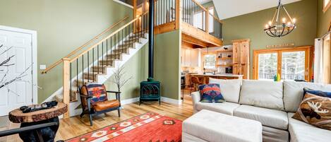 A spacious living room with a staircase, a fireplace, and a cozy seating area.