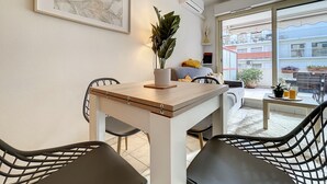 Un espace repas comprenant une table, des chaises et une plante en pot.