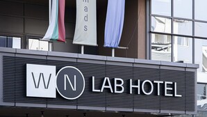 A hotel sign with the name "WON LAB HOTEL" and flags above it.