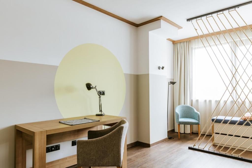 Una habitación con escritorio, silla y una hamaca colgante.