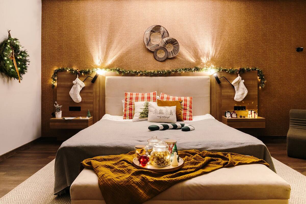 A cozy bedroom with a bed, bedside tables, and a nightstand.
