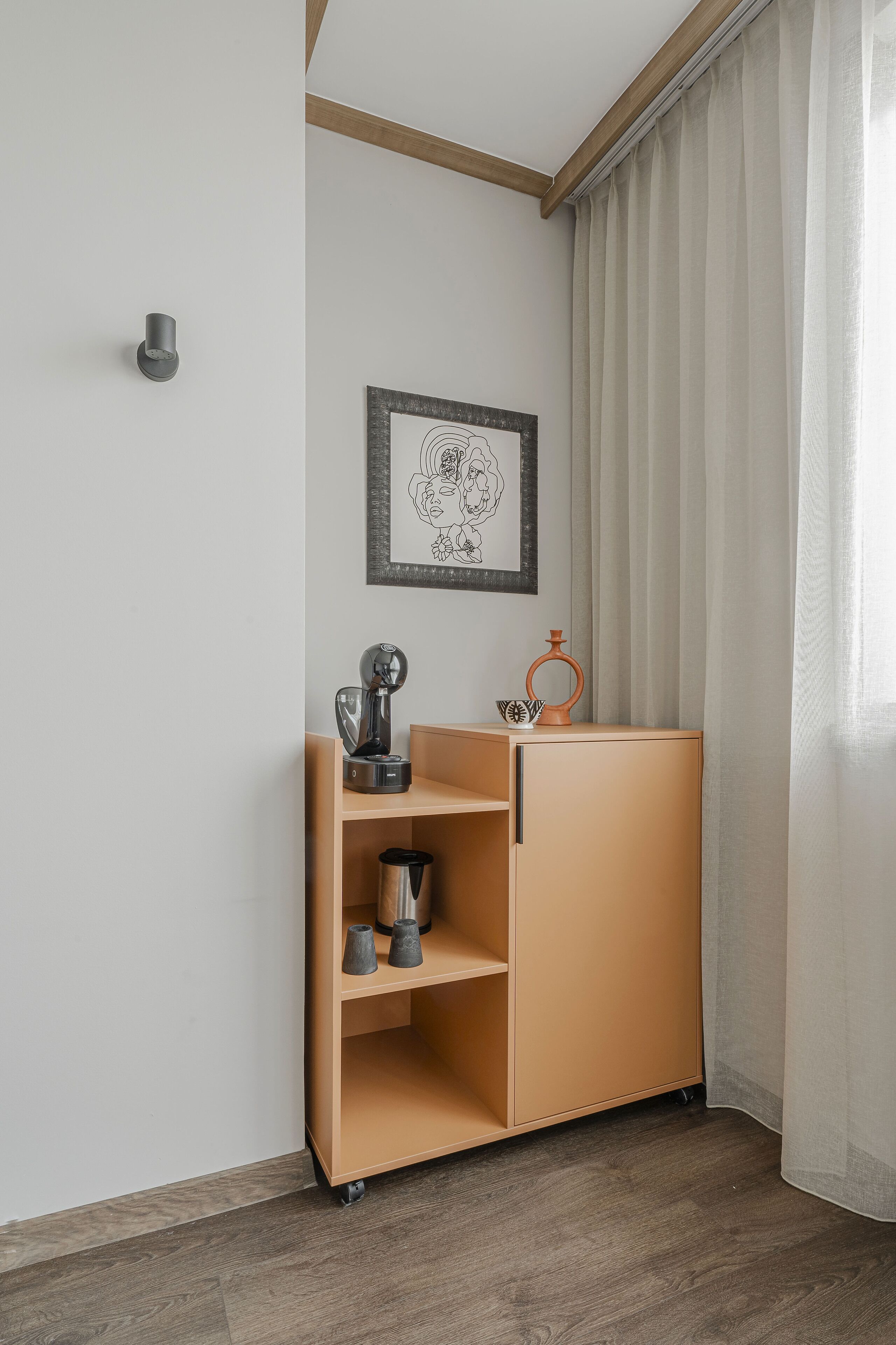 Quarto nos fundos com um armário de madeira, uma obra de arte emoldurada e uma janela com cortinas.