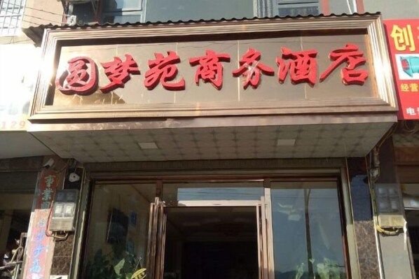 Un hotel con un letrero que muestra su nombre en letras rojas.