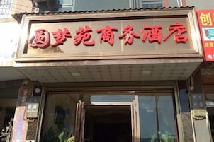 Un hotel con un letrero que muestra su nombre en letras rojas.