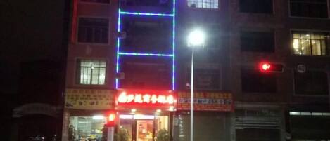 A multi-story building with illuminated signage and a ground-level entrance.