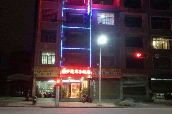A multi-story building with illuminated signage and a ground-level entrance.