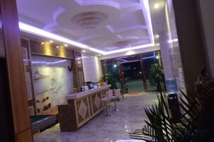 Un hall de hotel con mostrador de recepción, zona de estar y un amplio ventanal.