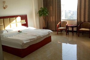 Relax in this serene space with a large bed, potted plant, and comfortable seating area.