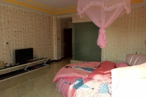 Relax in a traditional room with a patterned wallpaper, green accent wall, and a comfortable bed with a canopy.