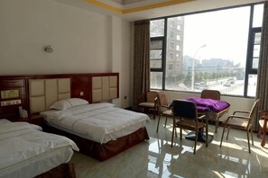 A hotel room with two beds, a desk, and a chair. - Yuanmengyuan Hotel (Guangnan)