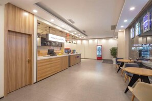 A modern interior with a reception desk, seating area, and vending machines. - litinghotel (Zhangjiagang)