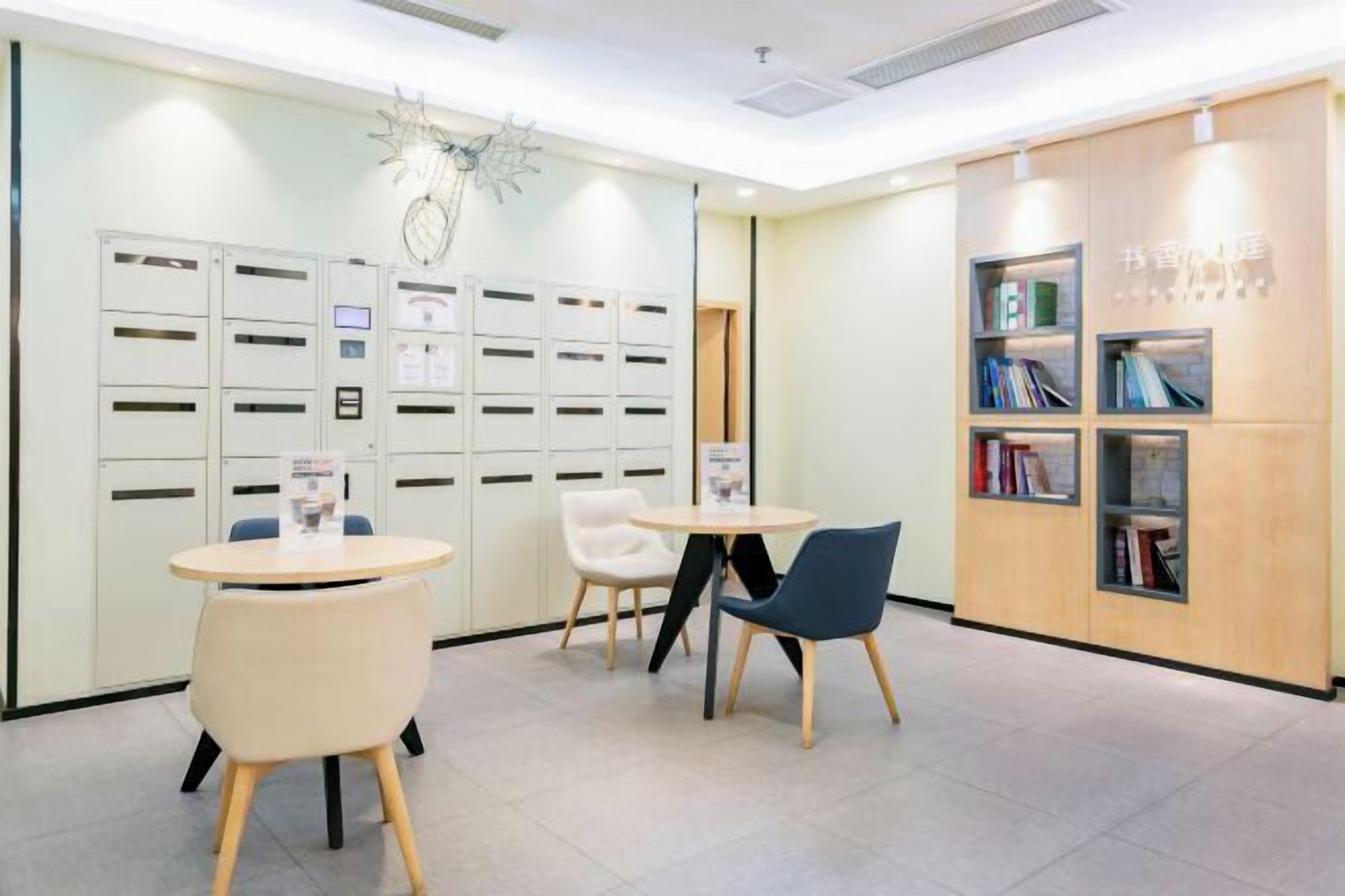 A reception area with a modern design, featuring a reception desk, seating area with chairs, and a bookshelf with books.