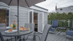 An outdoor patio with a round table, chairs, and a bottle of champagne. - Sea Breeze Apt 2 - 2 Bed - Horton Beach (Swansea)