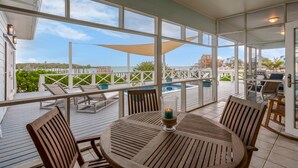 A covered outdoor area with a pool, wooden furniture, and a view of the sea. - Shore Leave – Relax, Unwind & Enjoy Paradise in Style (Elbow Cay)