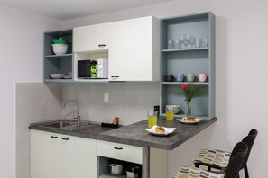 A modern kitchen with a built-in sink, white cabinets, and a grey countertop. - Beslema comfort one bedroom apartment with balcony and sea view (Dubrovnik)