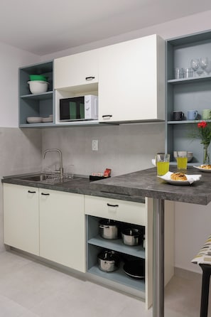 A modern kitchen with white cabinets, a granite countertop, and stainless steel appliances. - Beslema comfort one bedroom apartment with balcony and sea view (Dubrovnik)