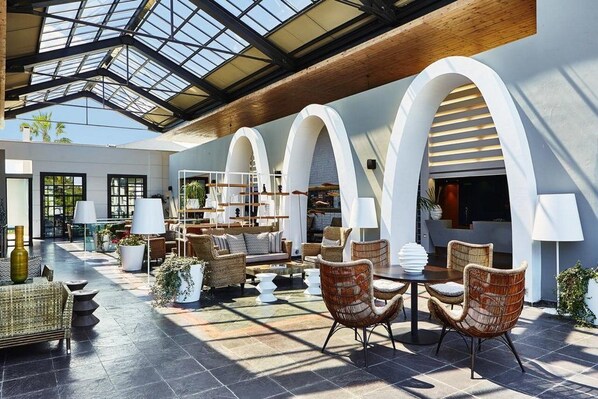A spacious indoor area with a high ceiling, large windows, and a modern design. - Ilio Mare Beach Hotel by GHH (Thasos)