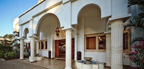 Un edificio con múltiples arcos, columnas y una fuente.