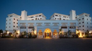 A large hotel with a symmetrical facade, multiple floors, and a central entrance with arches. - Lantana Galu Beach (Diani Beach)