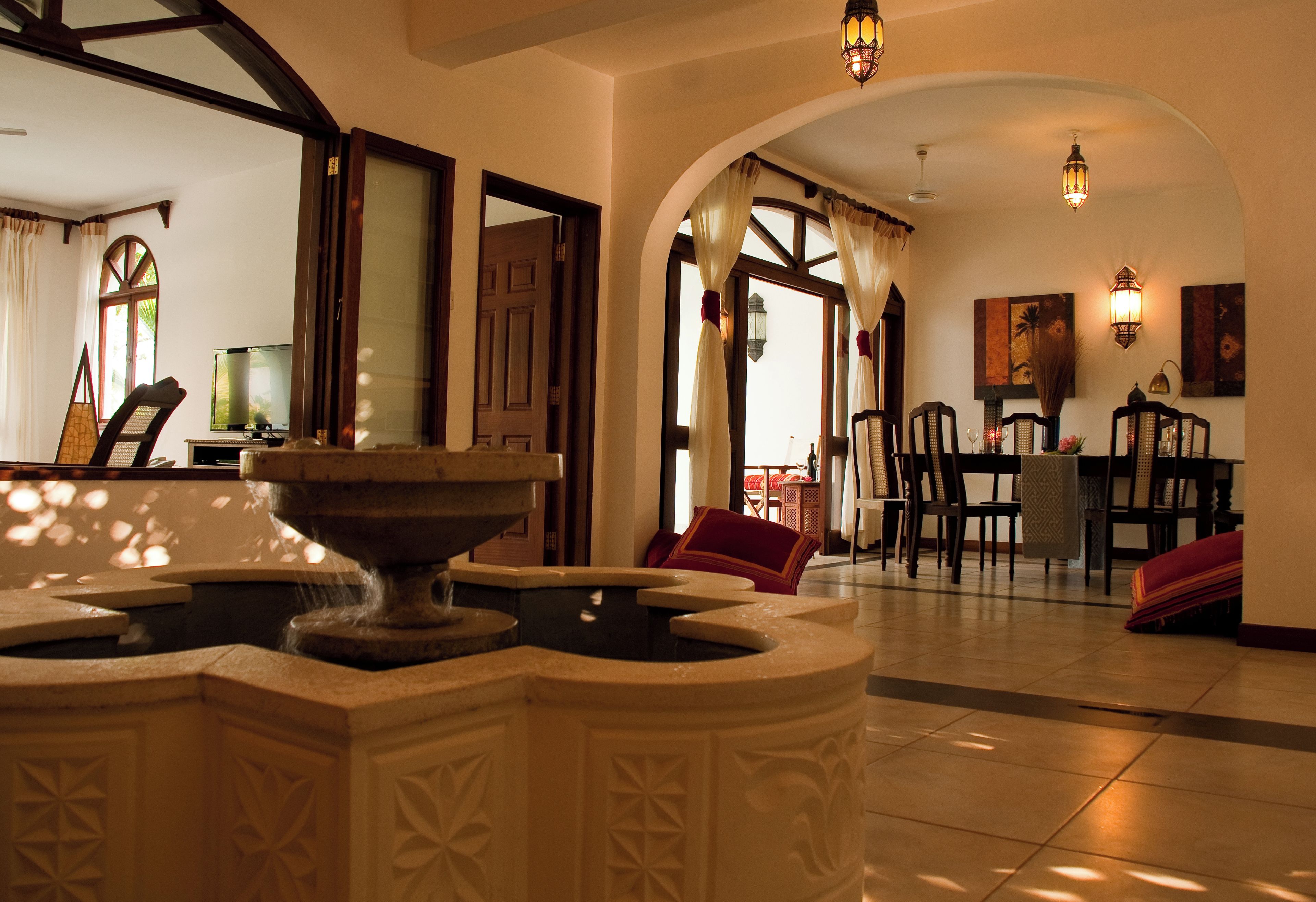 A lobby with a fountain, a dining area, and a view of the outside.
