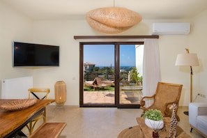 Relax in this stylish living room with a flat-screen TV, dining table, and comfortable seating area leading to an outdoor patio.