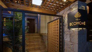 A staircase leading to a room with a wooden door and a sign that reads "Villa EcoHome". - EcoHome Villa (Chania)