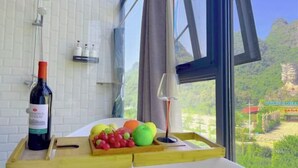 A kitchen counter with a bottle of wine, a fruit tray, and a candle. - Yangshuo Xitian Yueshan Homestay (Eternal Love Store) (Yangshuo)