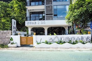 Un bâtiment moderne avec une enseigne sur laquelle on peut lire « SÛR, JE LE FAIS » et une autre enseigne avec des caractères qui ne sont pas de l’anglais.