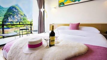 A hotel room with a bed, a bottle of wine, and a hat on a fluffy pillow.