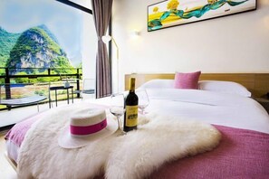 Une chambre d’hôtel avec un lit, une bouteille de vin et un chapeau posé sur un oreiller moelleux.