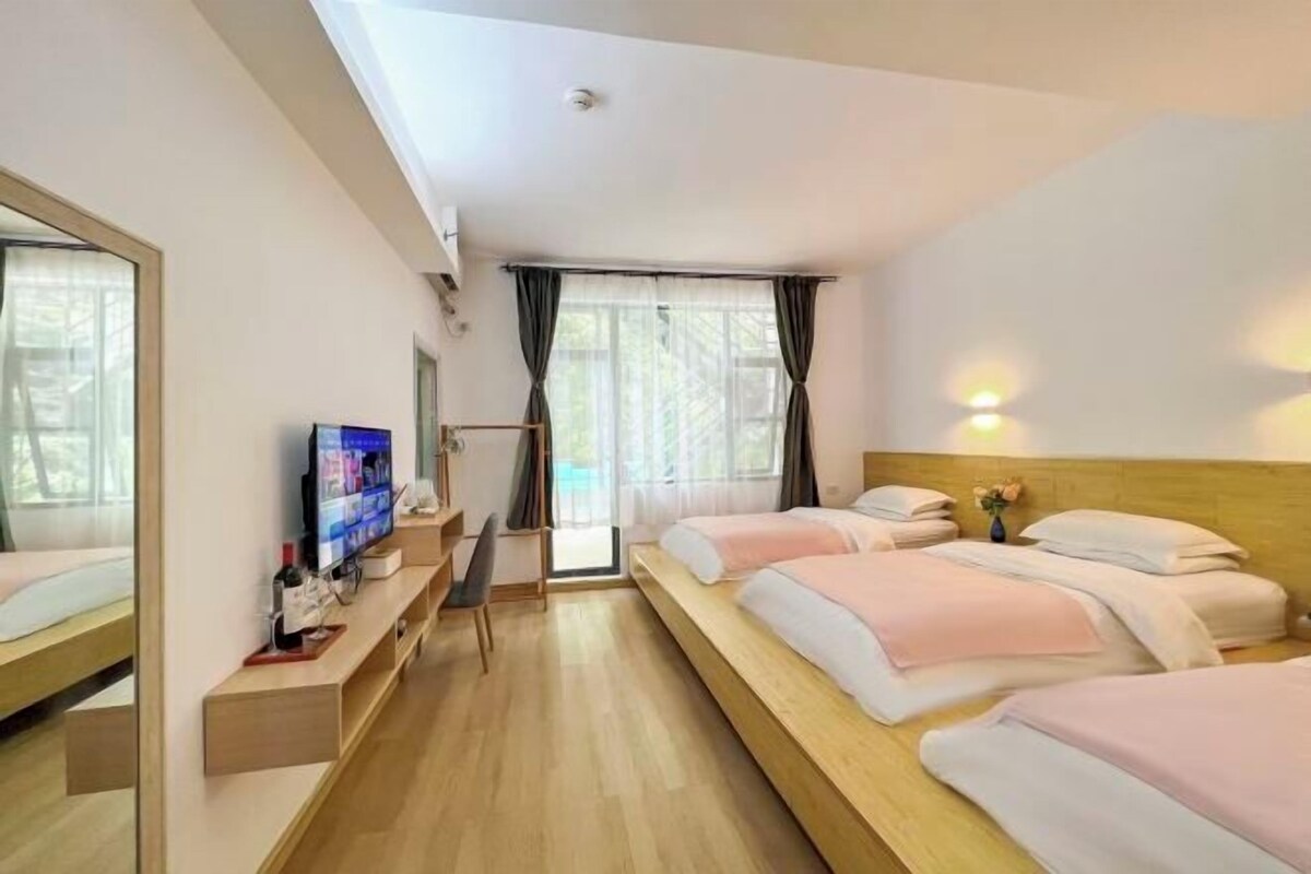 Une chambre d’hôtel moderne, dotée d’un grand lit, d’une télévision, d’un bureau et d’une fenêtre avec des rideaux.