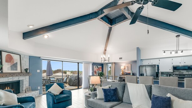 Una sala de estar amplia con chimenea, comedor y cocina.