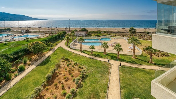 Un complexe hôtelier doté de plusieurs piscines, d’une plage et offrant une vue sur la mer.