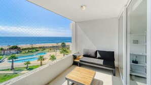 Un balcon avec vue sur la mer, une piscine et un canapé.