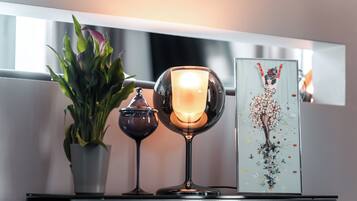 A table with a potted plant, a candle, and a framed artwork.