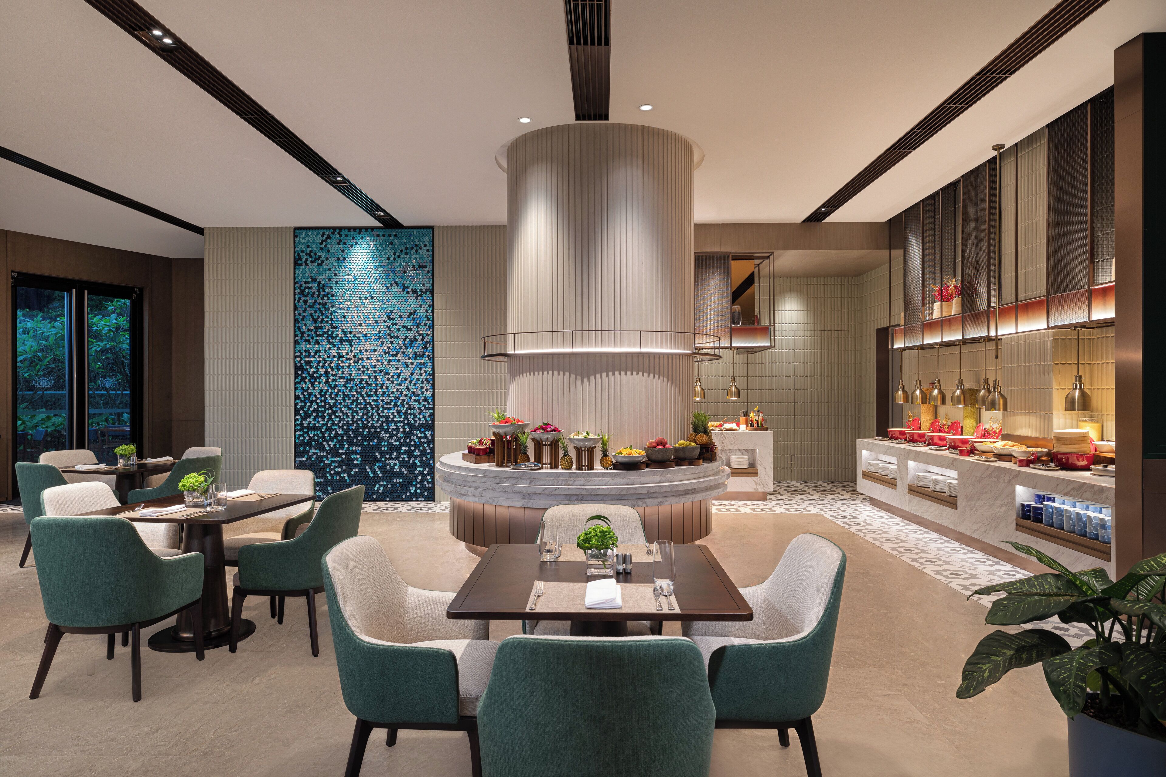 Un área de comedor moderna con una isla central, asientos y una encimera de cocina con diversos utensilios.