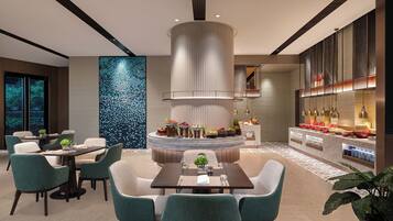 Un área de comedor moderna con una isla central, asientos y una encimera de cocina con diversos utensilios.