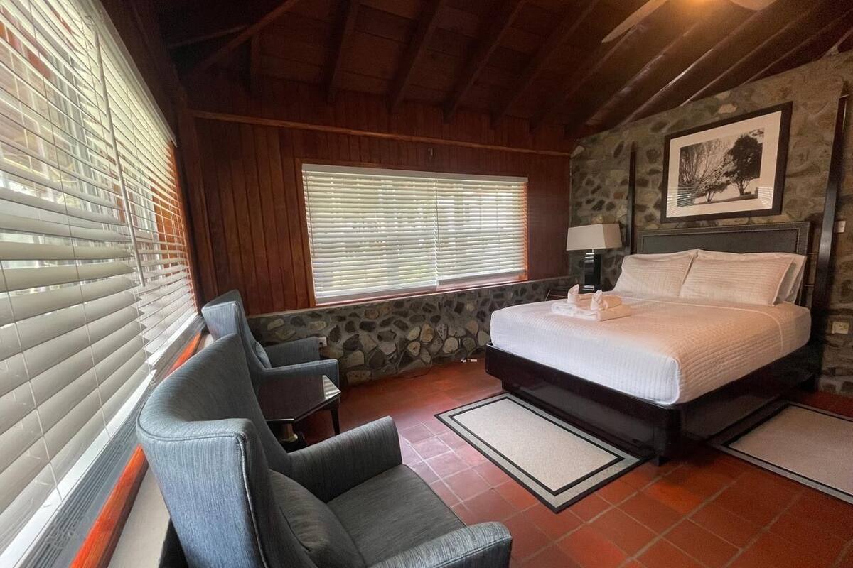 A bedroom with a bed, a desk, and a chair.