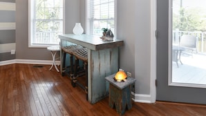A room with wooden flooring, a rustic bench, a small table, and a wall-mounted lamp. - 3 BR Beach House in Surfside Beach! Raycliff at the Beach (Surfside Beach)