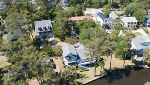 An aerial view of a residential area with houses, trees, and a body of water. - 3 BR Beach House in Surfside Beach! Raycliff at the Beach (Surfside Beach)