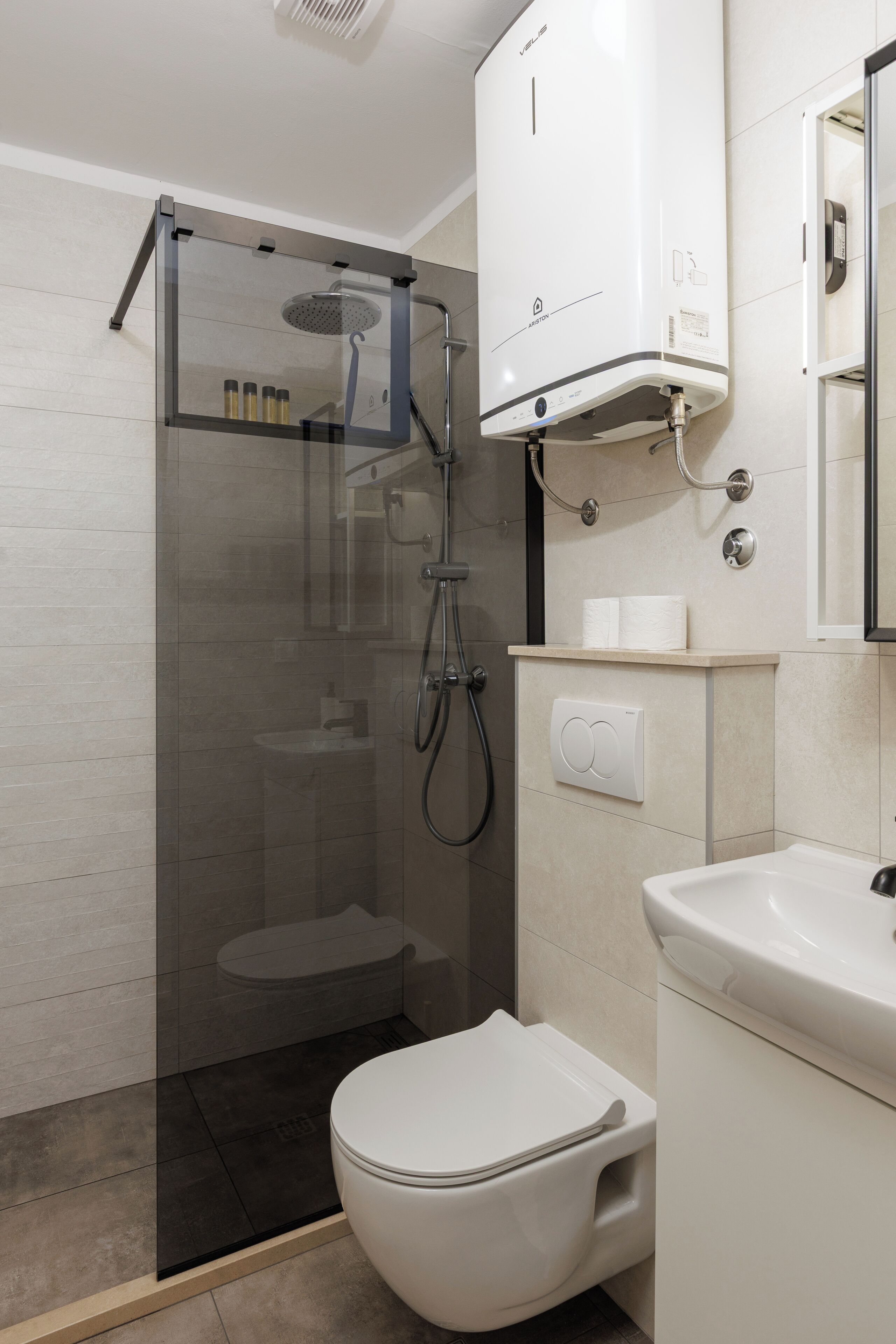 Un baño moderno con ducha de vidrio, inodoro y lavamanos.