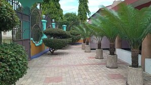 A paved pathway with potted plants and a gated entrance.