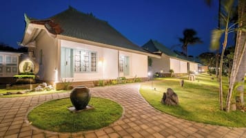 A traditional building with a tiled roof, a paved pathway, and a well-maintained lawn.