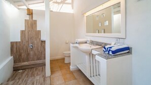 A modern bathroom with a wooden shower, a white sink, and a large mirror.
