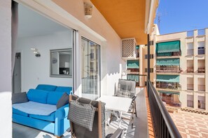 A balcony with a blue sofa, a small table, and a chair. - Holiday Apartment "Albaida 3j" near Beach with Shared Pool & Wi-Fi (Nerja)