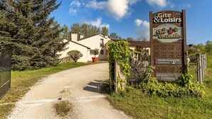 A sign for 'Gite & Loisirs' with a rustic wooden design, indicating a lodging and recreational facility.