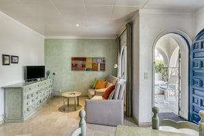 A living room with a television, sofa, and dining area.