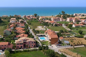 Una zona residencial costera con casas, una piscina y vistas al mar.